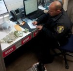 Officer G. Cantu tags drugs and money seized.
