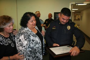 Lieutenant Alberto Emilio Villarreal reads the certificate of promotion with his family.