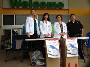 Pharmacy students Lisa Eggleston, Angelic Toy, and Heather Goodman wait to accept the medications with Officer Cervantes at the HEB in Flour Bluff.